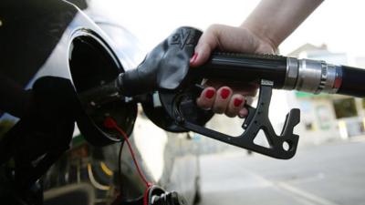 Hand on petrol pump filling up car