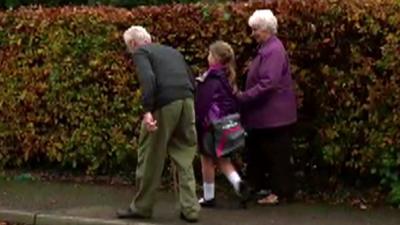 Schoolgirl walking with grandparents