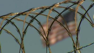 Barbed wire with flag in the background