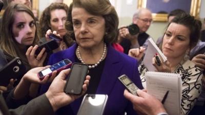 Dianne Feinstein surrounded by reporters