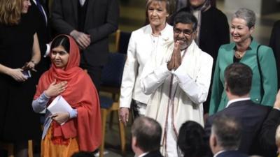Satyarthi (R) and Malala Yousafzai (L) salute guests upon arrival for the Nobel Peace Prize awarding cere