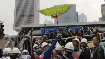 A worker holds an umbrella near the government headquarters