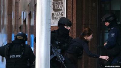 Woman fleeing Sydney cafe siege with three armed Australian police officers