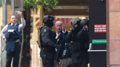 A hostage runs to safety outside the Lindt Cafe