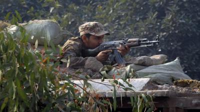 A Pakistani soldier taking position outside the school