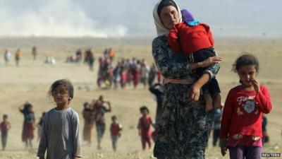 Displaced people from the Yazidi religious minority walk from Mount Sinjar towards the Syrian border (11 August 2014)