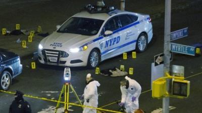 Investigators work at the scene where two NYPD officers were shot