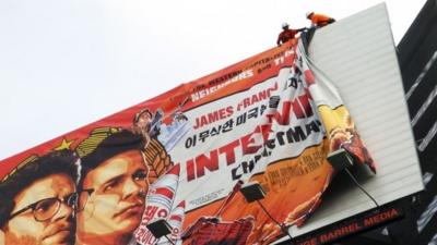 Workers remove the poster for "The Interview" from a billboard in Hollywood, California, December 18, 2014