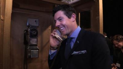 Rory McIlroy on the phone using a payphone