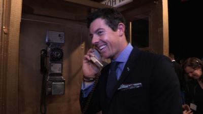 Rory McIlroy on the phone using a payphone