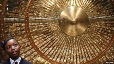 A schoolgirl stands next to a lottery drum during the draw for Spain's Christmas lottery El Gordo in Madrid on 22 December 2014