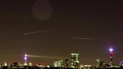 The path of The International Space Station (top straight line) is seen from central London on December 24