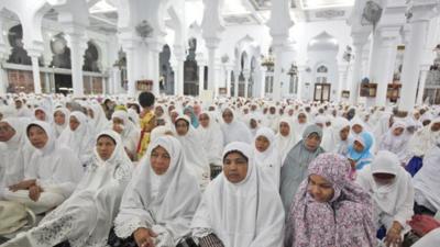 Acehnese women attend a prayer for the victims of Indian Ocean tsunami ahead of its 10th anniversary at Baiturrahman Grand Mosque in Banda Aceh, Aceh province, Indonesia