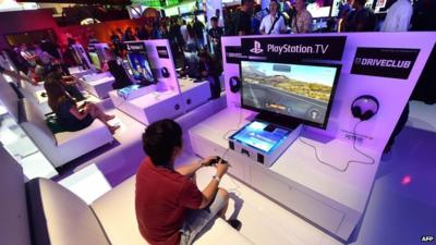 File picture shows people testing the new PlayStation TV consoles in LA (June 2014)