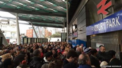 Crowds of people outside barricaded entrance to Finsbury Park train station