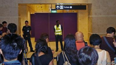 Journalists crowd the waiting area for relatives of passengers