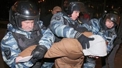 Police officers detain a supporter of opposition leader and anti-corruption blogger Alexei Navalny during a rally in central Moscow, Russia, 30 December 2014