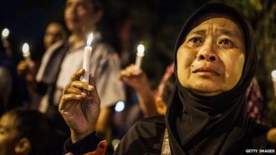 A woman cries as she prays for the victims of the AirAsia flight QZ8501 crash at the Indonesian Air Force Military Base Operation Airport in Surabaya, Indonesia, 31 December 2014