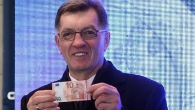 Lithuanian Prime Minister Algirdas Butkevicius withdraws euros from a bank machine during a ceremony in Vilnius, on January 1, 2015