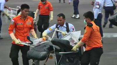 Recovery teams carrying plane wreckage