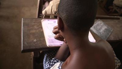 Girl sitting at desk at school from behind