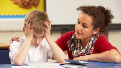 Teacher helps pupil with schoolwork