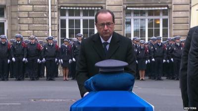 Francois Hollande putting Legion d'honneur medal on coffin of officer killed in Paris attacks