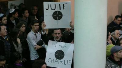 Man in synagogue holding placards