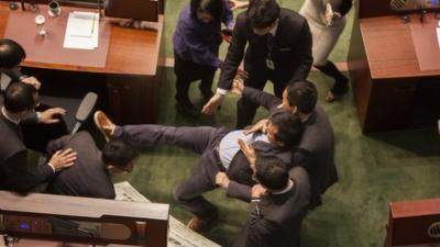 Pan-democratic lawmaker Raymond Chan Chi-chuen is forcibly removed from the chamber
