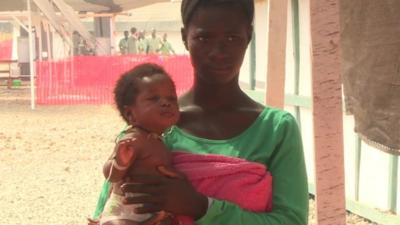 An Ebola survivor looks after a baby