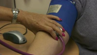 Doctor checking patient's blood pressure