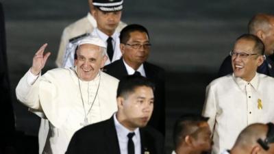 Pope Francis (L) waves next to Philippine President Benigno Aquino III (R)