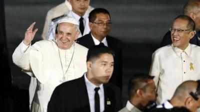Pope Francis (L) waves next to Philippine President Benigno Aquino III (R)