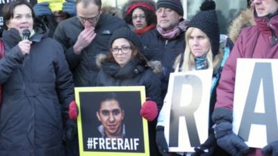 Ensaf Haidar holding a picture saying #freeraif