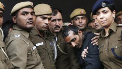 Policemen escort driver Shiv Kumar Yadav (in black jacket) who is accused of a rape outside a court in New Delhi December 8 2014