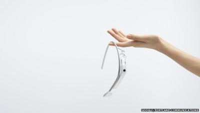 Woman's hand with Google Glasses balanced on her index finger