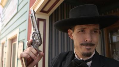 Man from OK Corral in Arizona holds up a gun