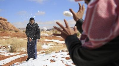 Men play with snow in Saudi Arabia