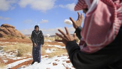 Men play with snow in Saudi Arabia