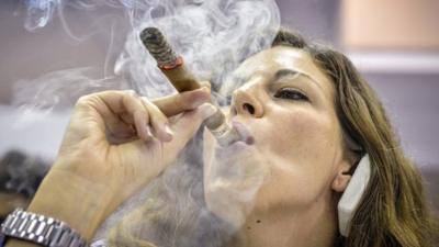 Woman smokes Cuban cigar at cigar festival in Havana on 27 February 2014