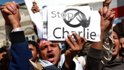Yemeni protester holding up sign saying 'Stop Charlie'