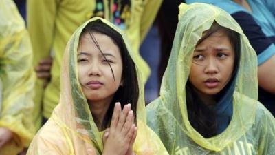 Young Filipino women pray during the visit of Pope Francis