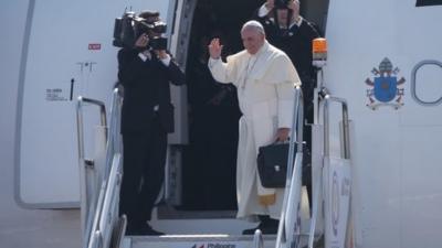 Pope Francis waves from the steps of his aircraft as he leaves Villamor Airbase for Rome