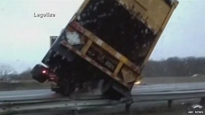 Close-up of tractor-trailer tipping over as it jack-knifes across New Jersey Interstate