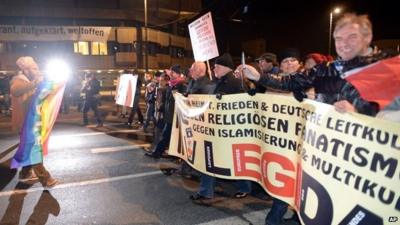 A counter demonstrator with a peace flag opposes the demonstration of Pegida