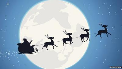 Father Christmas and reindeers silhouetted against the moon