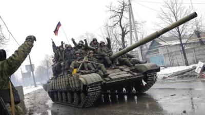 Armed pro-Russian rebels ride a tank in downtown Donetsk