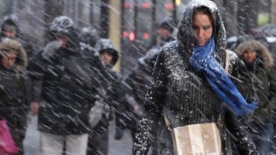 Pedestrians make their way through driving snow in midtown Manhattan in New York, Monday, Jan. 26, 2015
