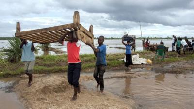 Members of a family displaced by recent floods belongings as they arrive at M'bwazi Primary School after crossing the flooded Ruo river in the area of Chief Mulolo in Malawi's southern Nsanje District on January 18, 2015.