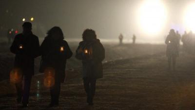 people pass in the dense snow during the commemoration of the 70th anniversary of the liberation of the former Nazi-German concentration and extermination camp